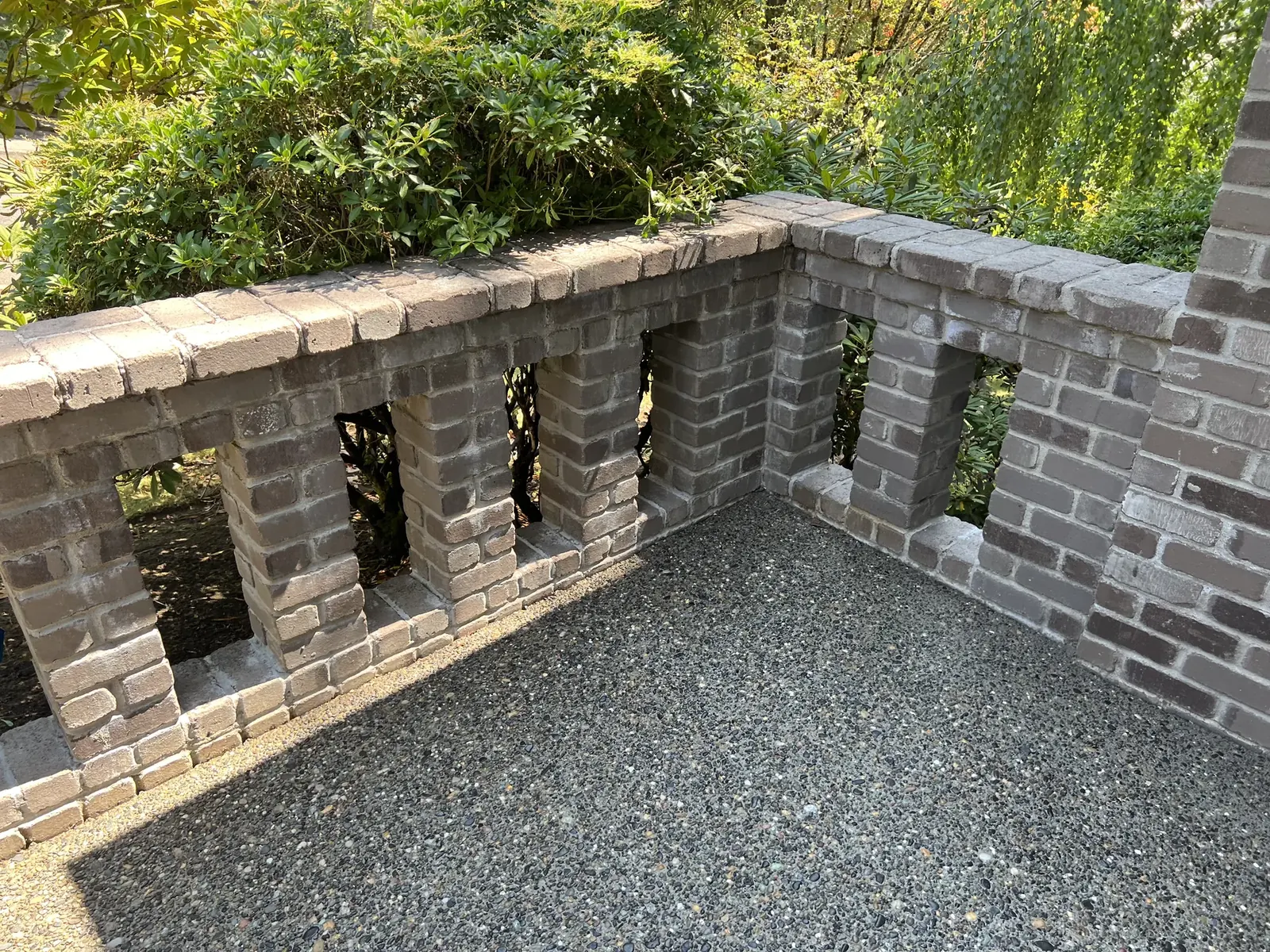 Brick wall and exposed-aggregate walkway after exterior cleaning