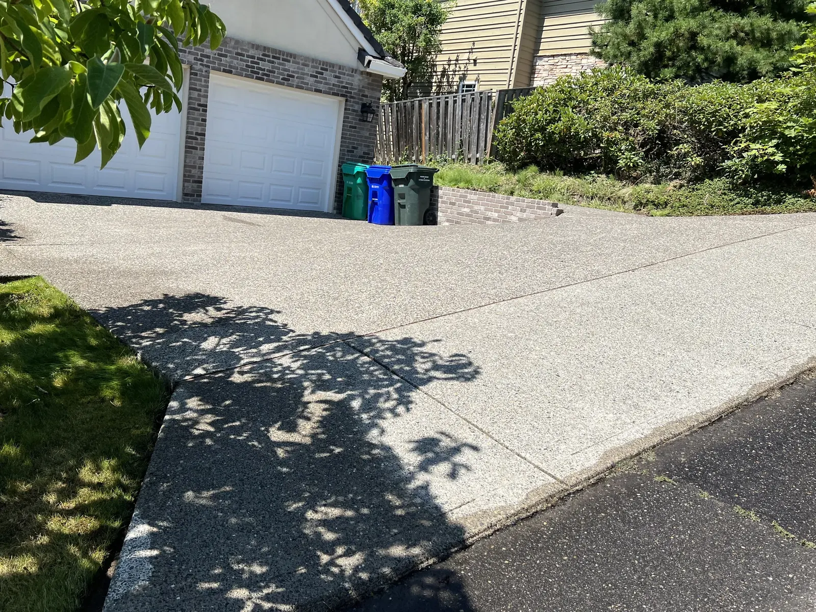 Wide finished view of a clean exposed-aggregate driveway near Barnes Road