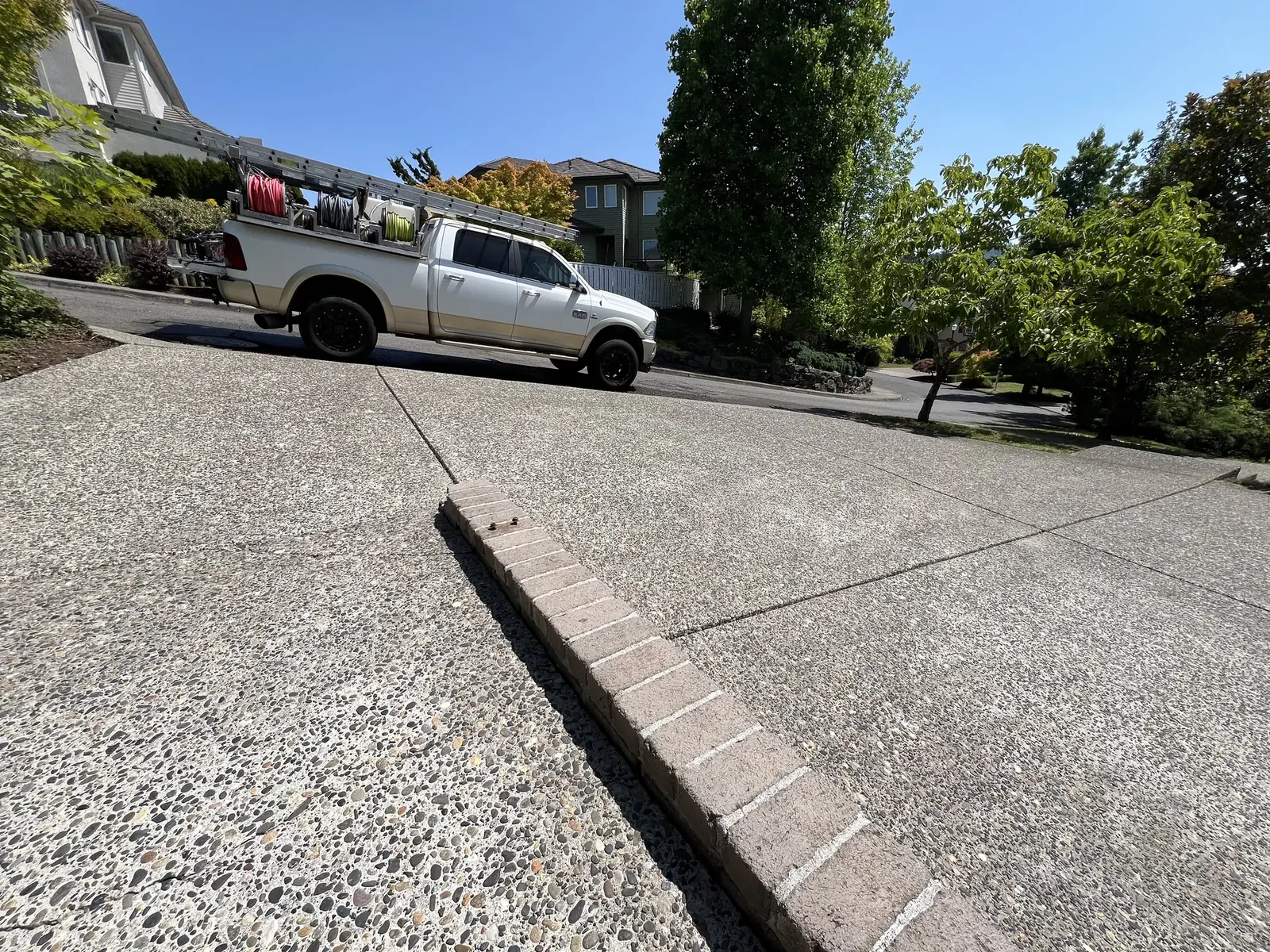 Clean exposed-aggregate driveway and brick wall near Barnes Road after pressure washing
