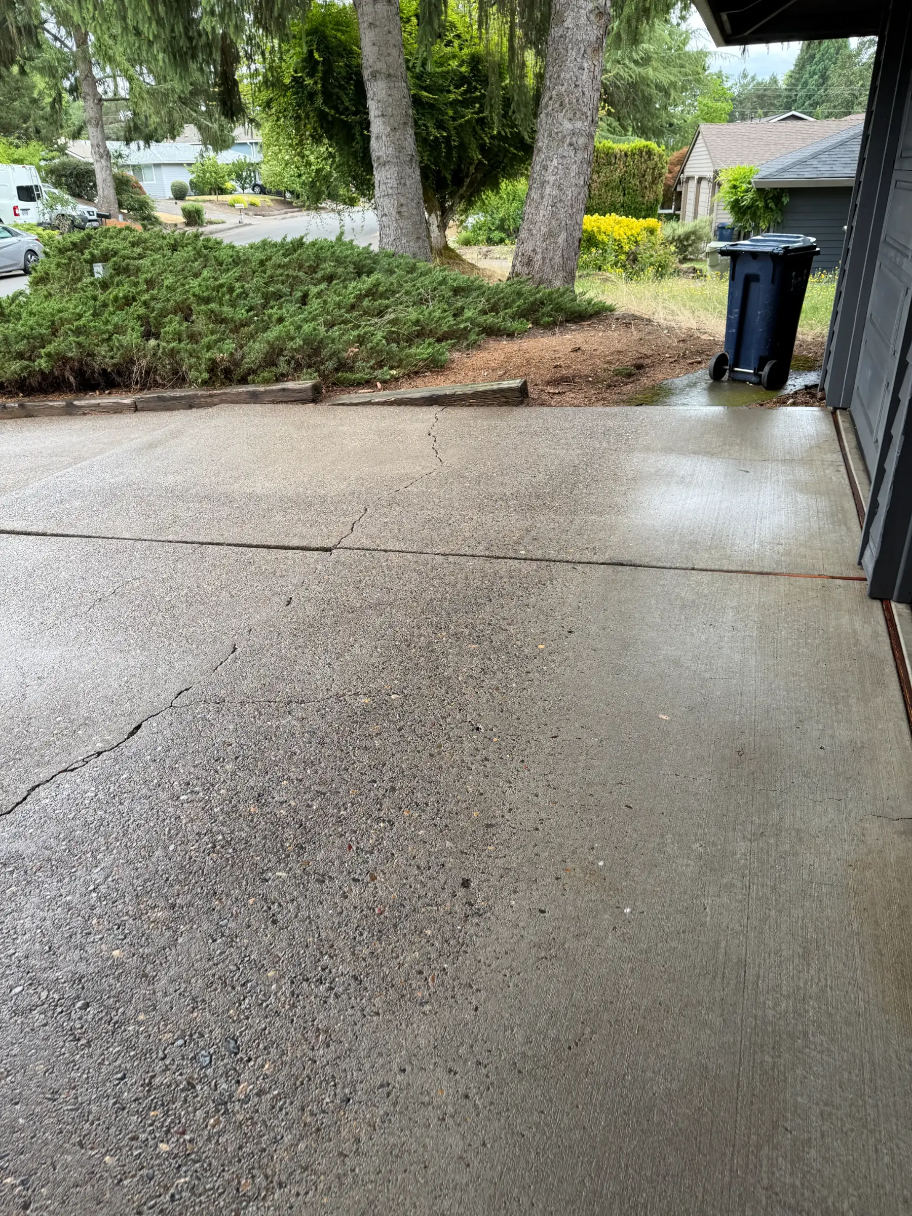 Driveway garage apron after pressure washing near Beaverton and Aloha with cleaner concrete and visible cracks