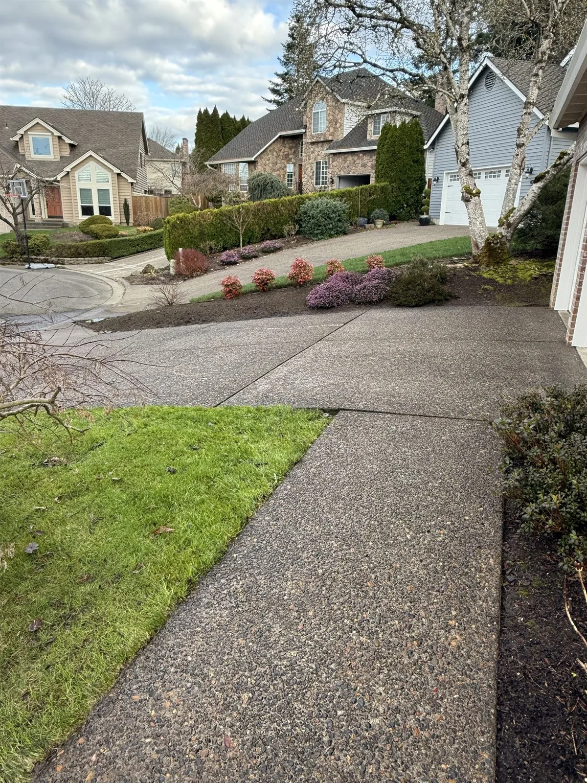 Cleaned exposed aggregate walkway leading toward a Beaverton driveway after pressure washing
