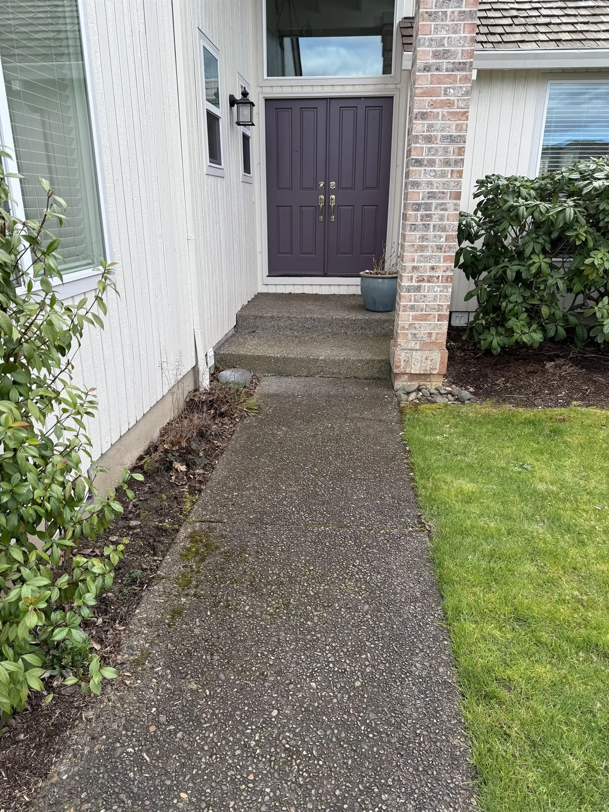 Front walkway in Beaverton before cleaning with moss and organic buildup near the entry