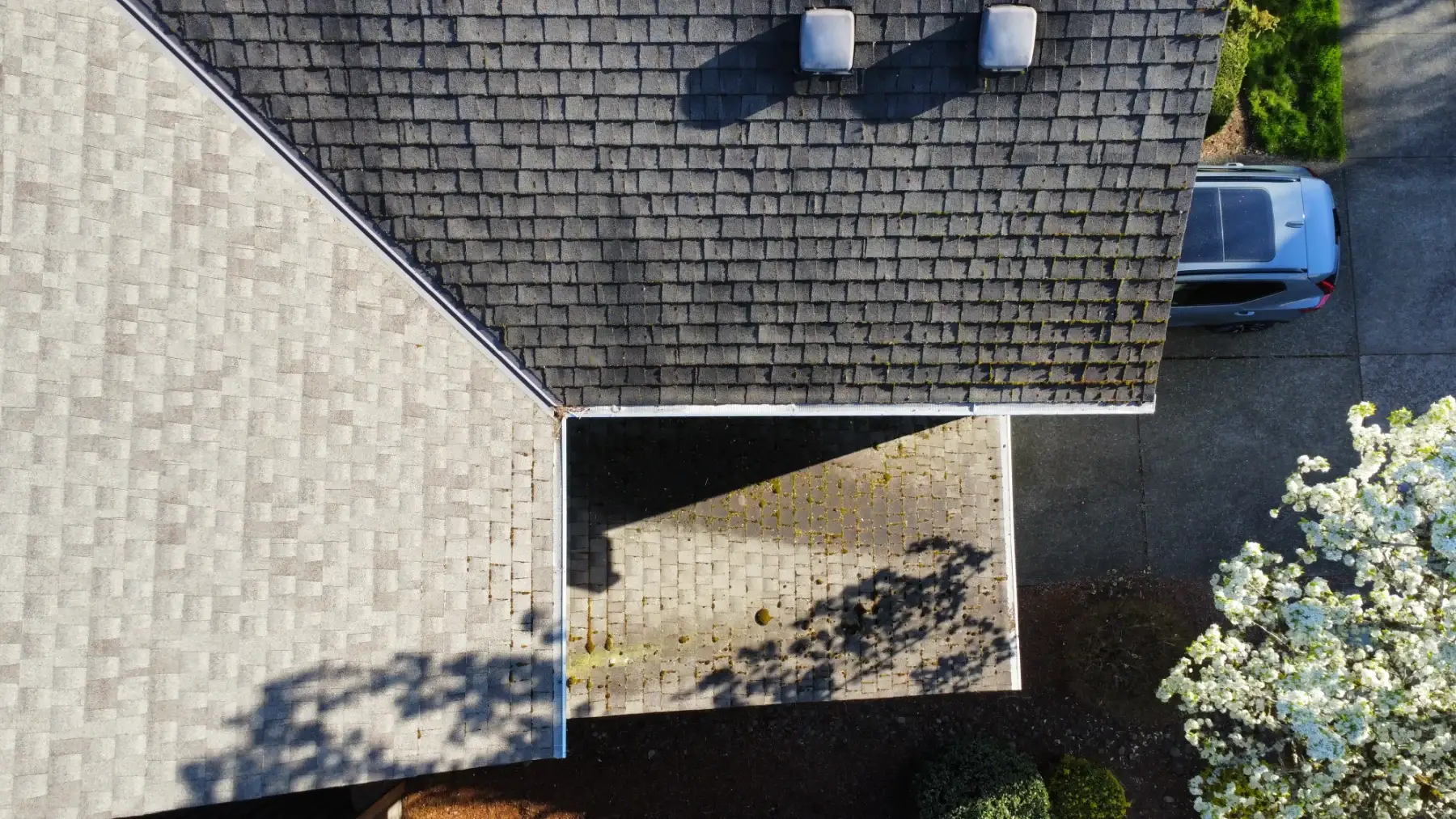 Drone view of a Beaverton roof and driveway showing partial roof treatment context