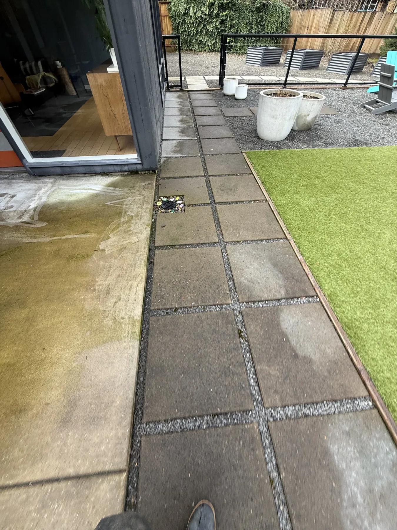 Patio slab joints near turf and a sliding door during Cedar Mill patio cleaning