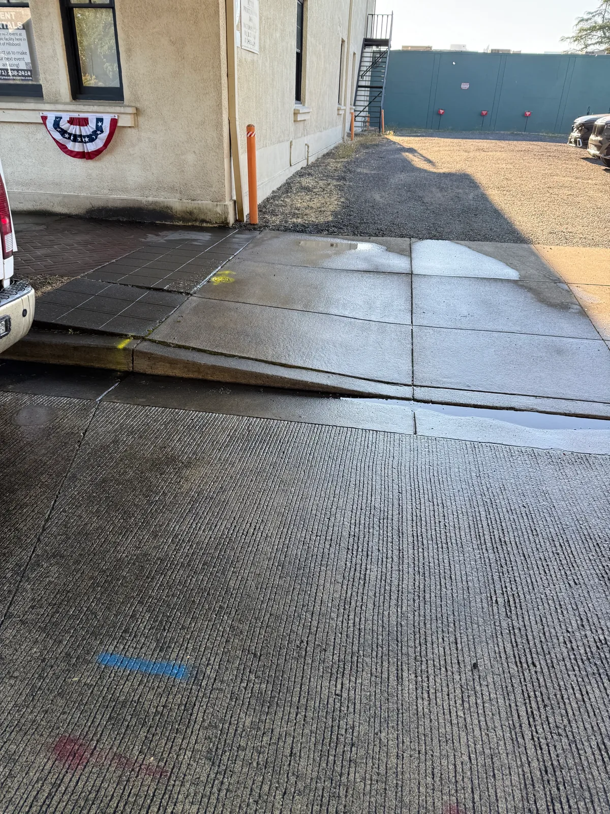 Wet cleaned sidewalk and curb ramp after parade chalk removal in Downtown Hillsboro