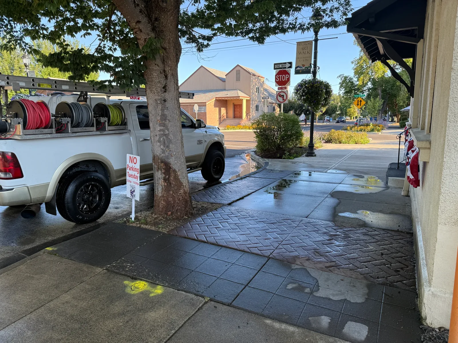 Wide Downtown Hillsboro jobsite view with Suds Doctor truck and wet sidewalk after chalk cleaning
