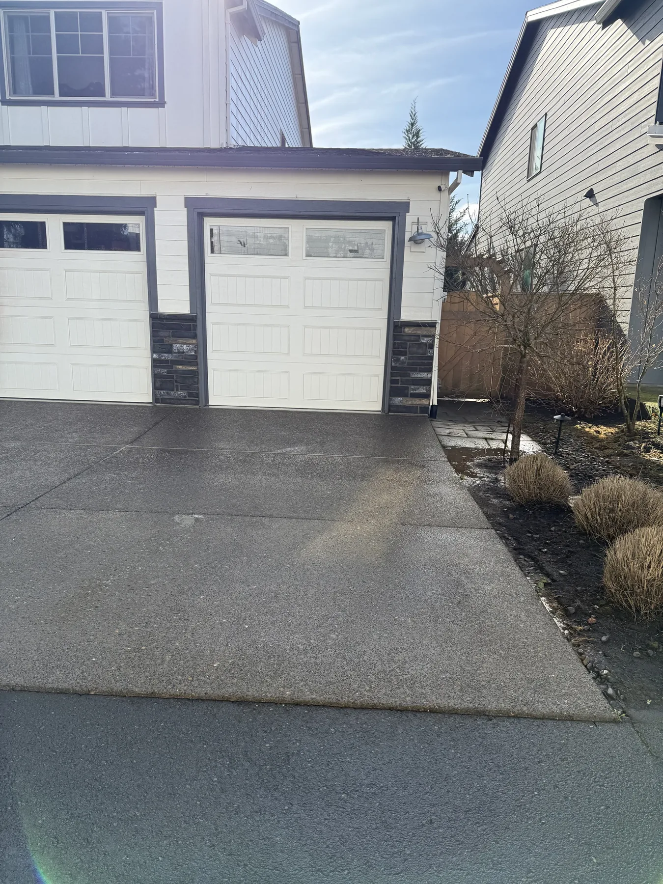 Cleaned Forest Grove driveway section in front of garage doors after pressure washing