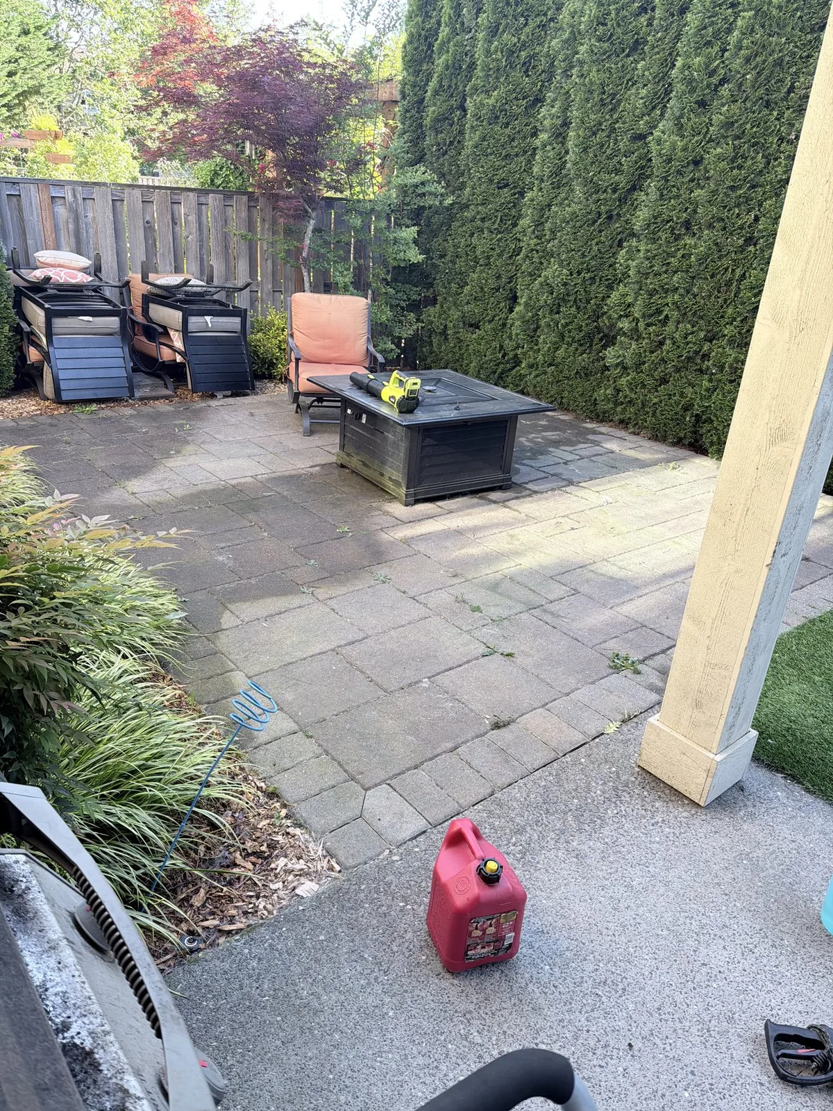 Back paver patio in Forest Grove before cleaning with weeds and patio furniture