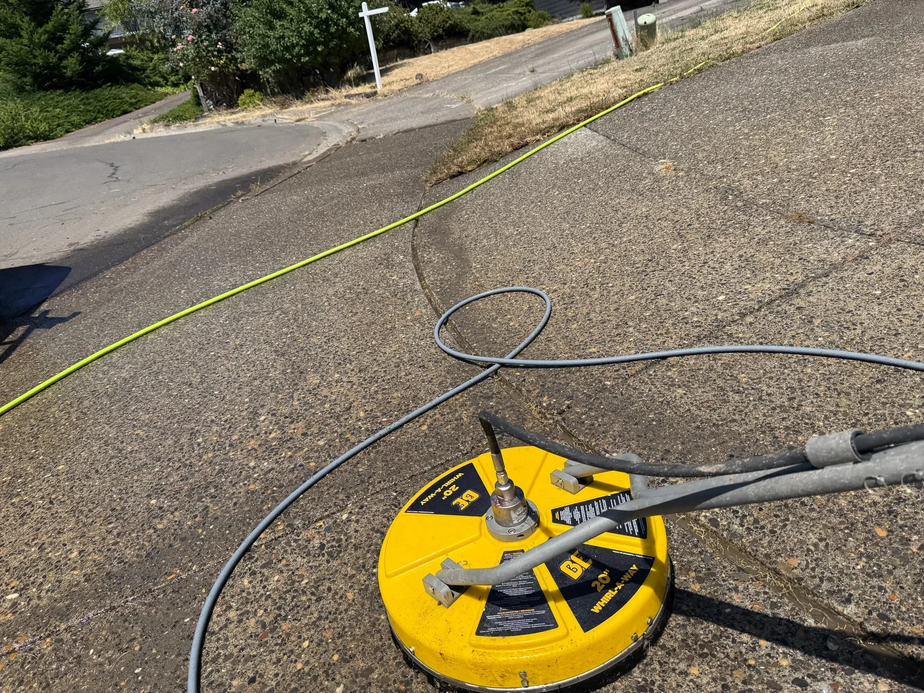 Close view of a pressure washing surface cleaner working across a Hillsboro driveway