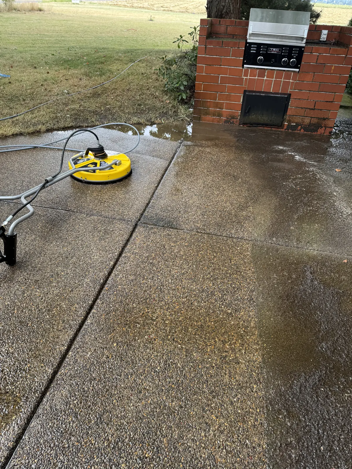 Surface cleaner working across a mossy concrete patio in Hillsboro Oregon