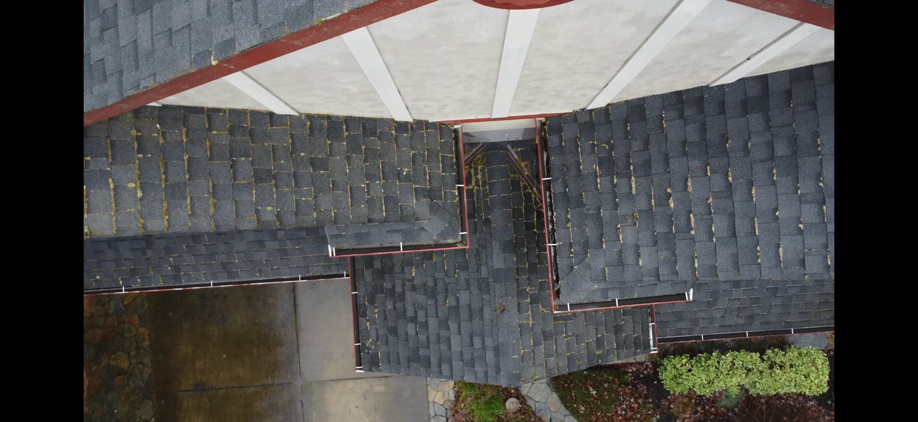 Overhead drone view of a Portland roof with light moss near gutters and roof edges