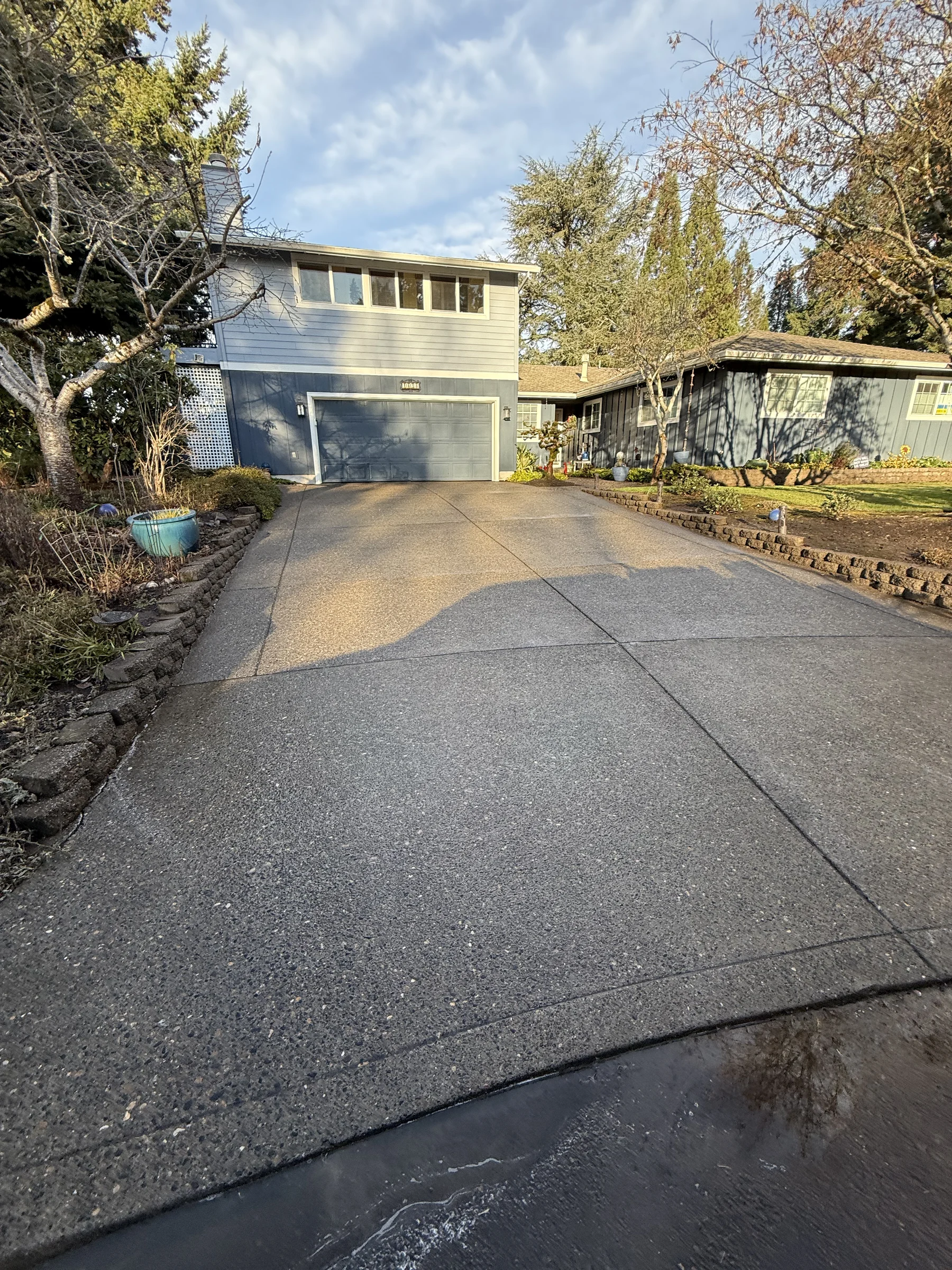 Cleaned Rock Creek driveway slope with small retaining wall after pressure washing