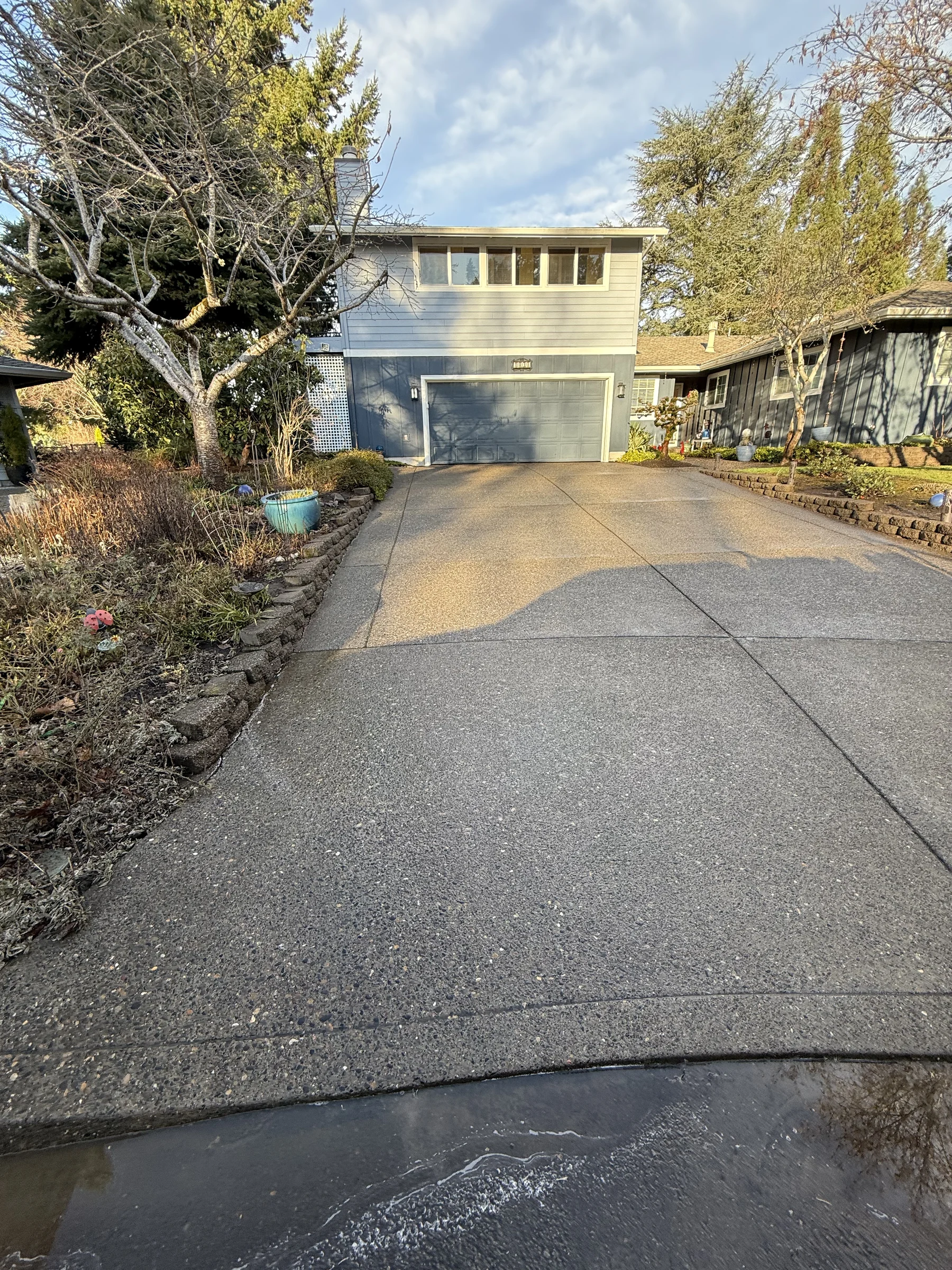 Rock Creek driveway showing cleaner and darker concrete areas during pressure washing