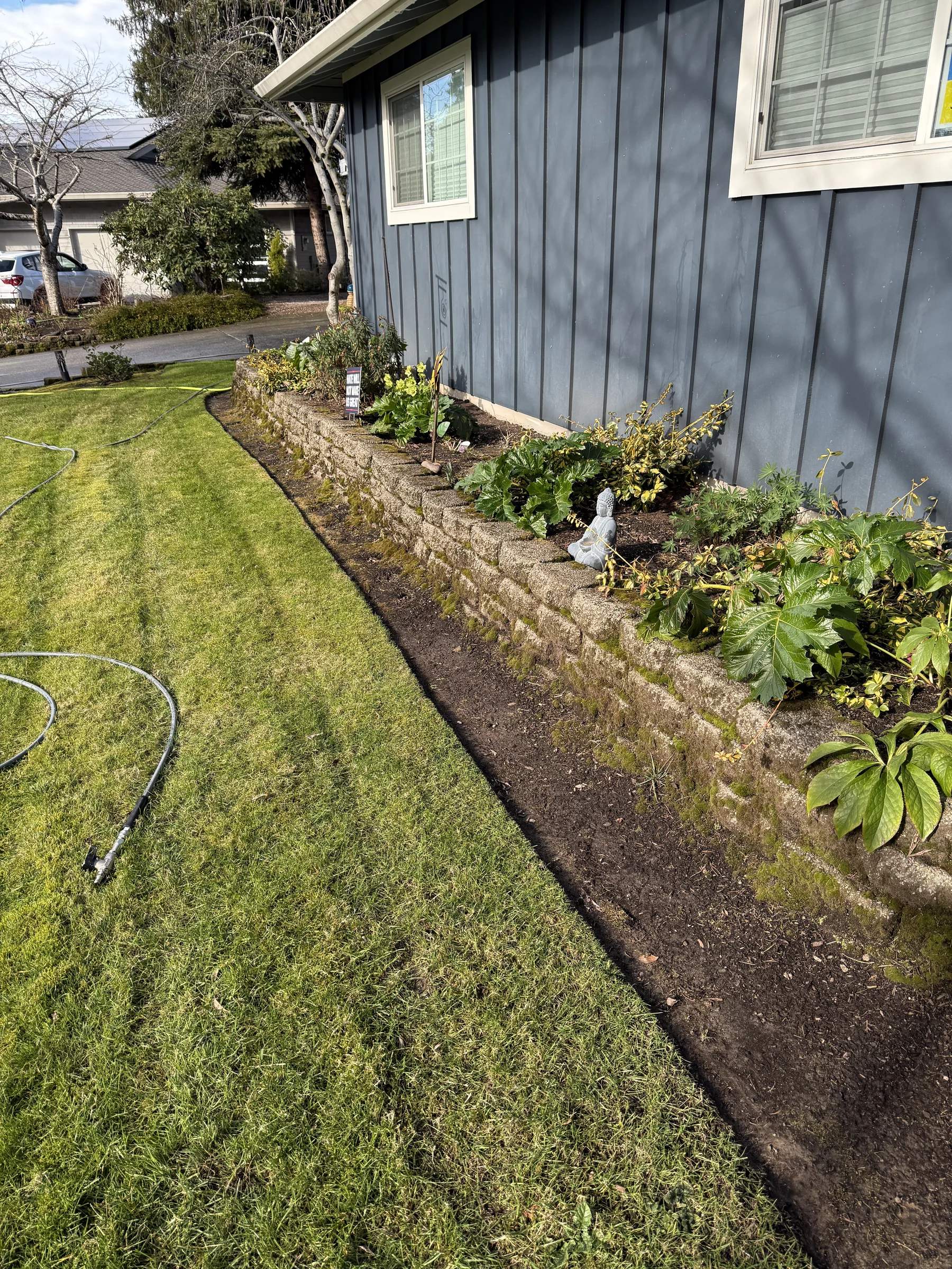 Small retaining wall and landscape edge after cleaning beside a Rock Creek driveway