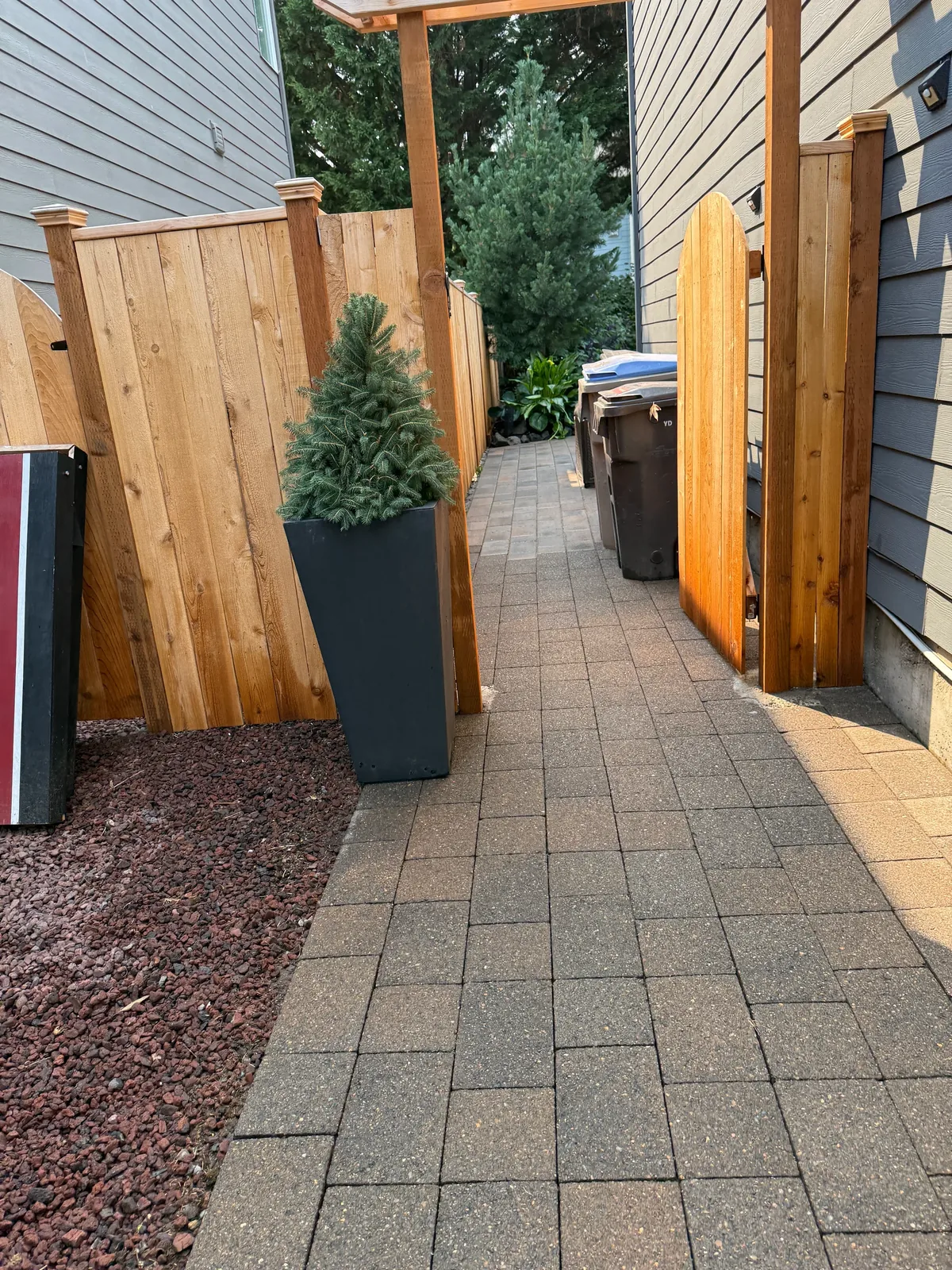 Clean paver walkway between a Sherwood home and wood fence after pressure washing