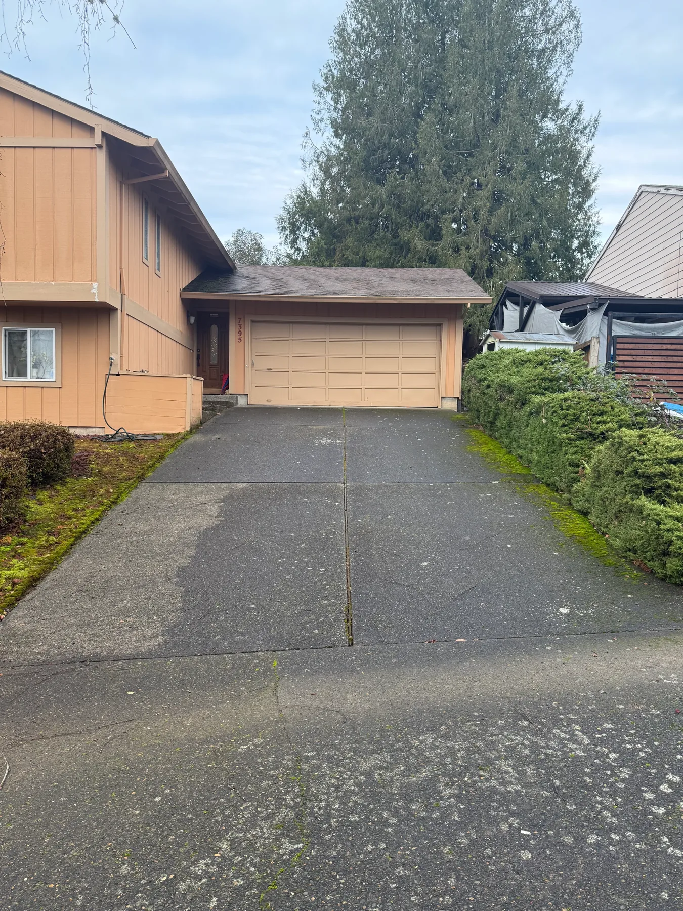 Wide view of South Beaverton driveway before pressure washing with dark exposed aggregate concrete