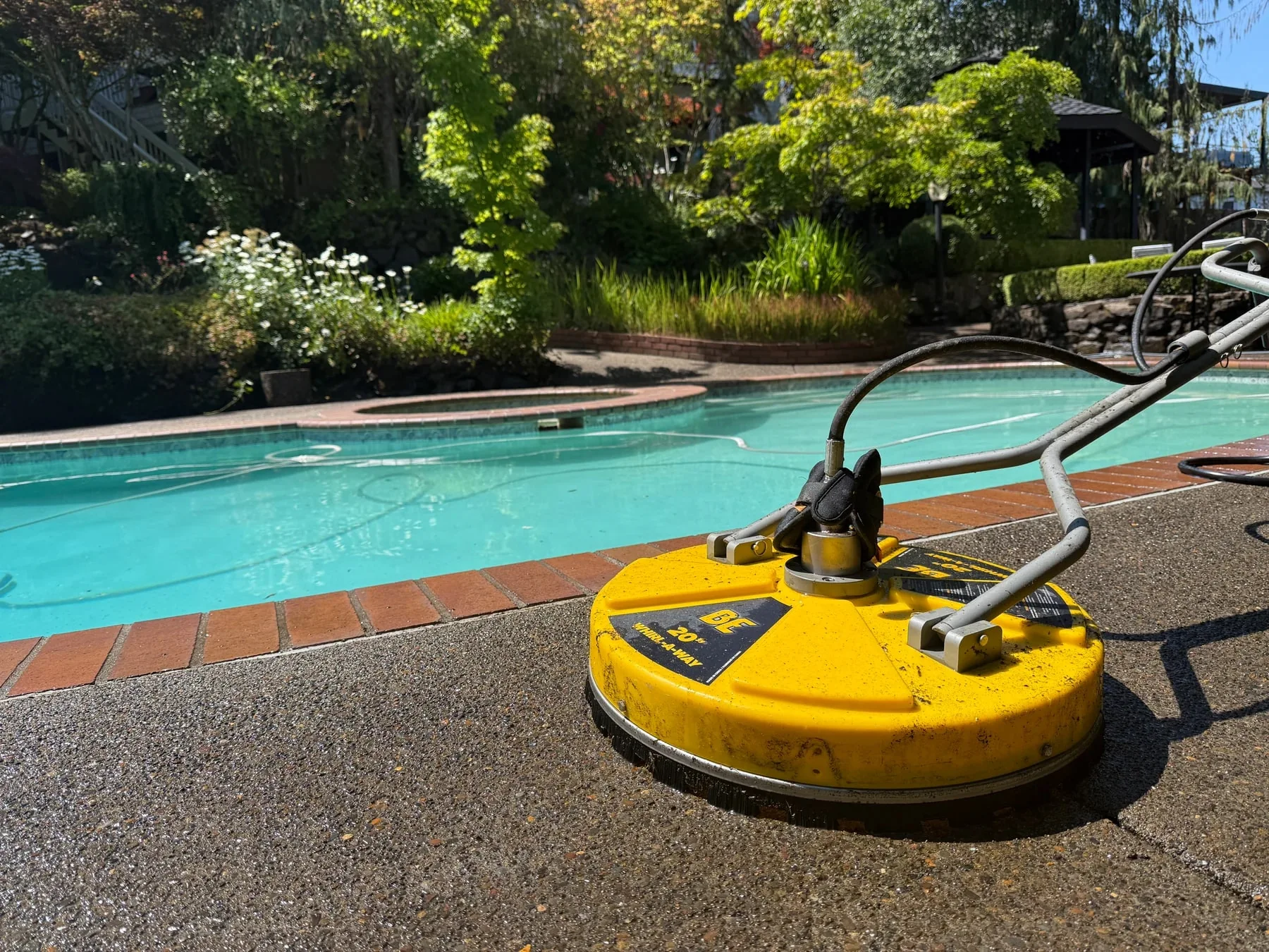 Surface cleaner on exposed-aggregate concrete beside a West Beaverton swimming pool